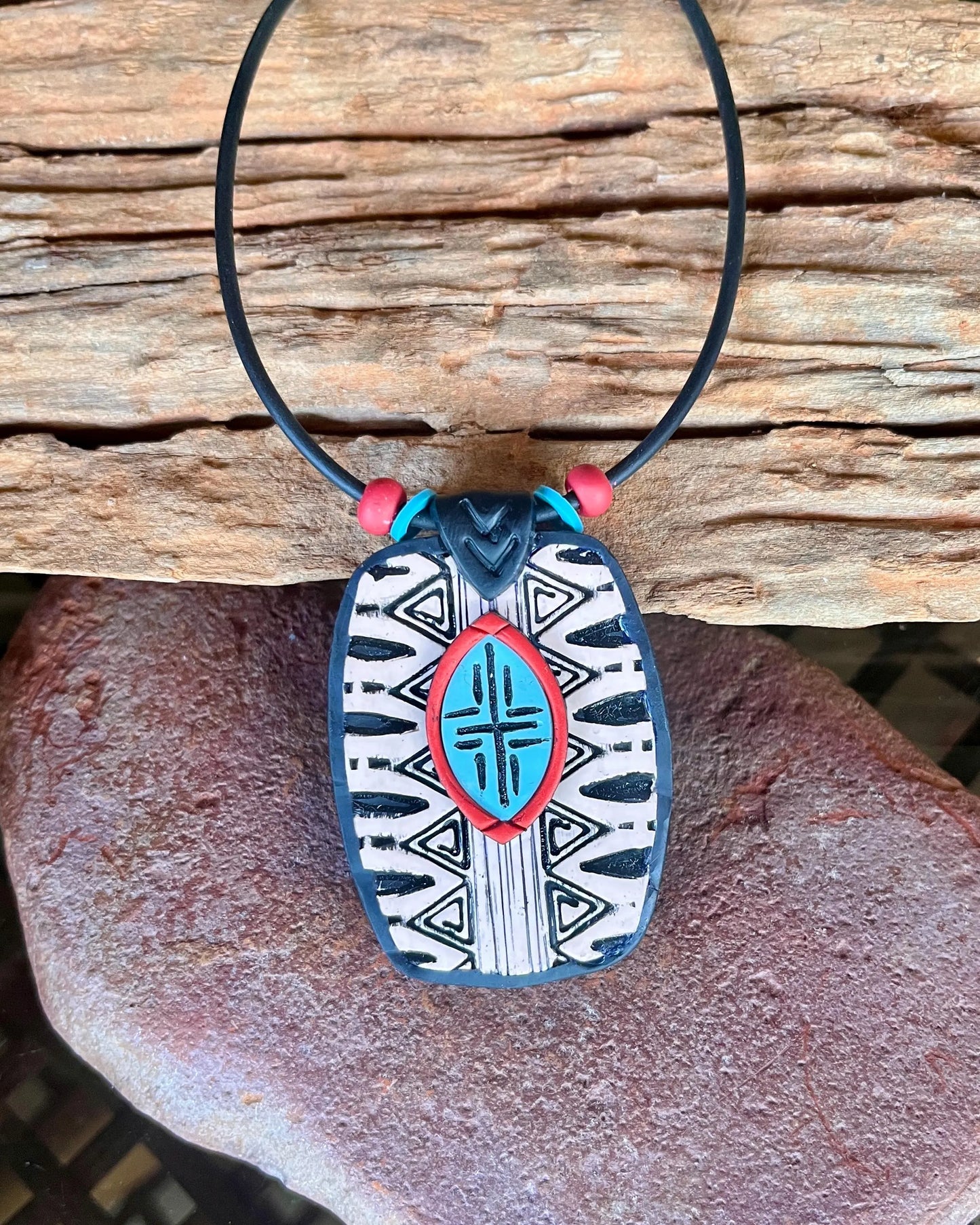 Beautiful, distinctive tribal textured, and layered polymer clay pendant. Black and white with turquoise and rust accents.