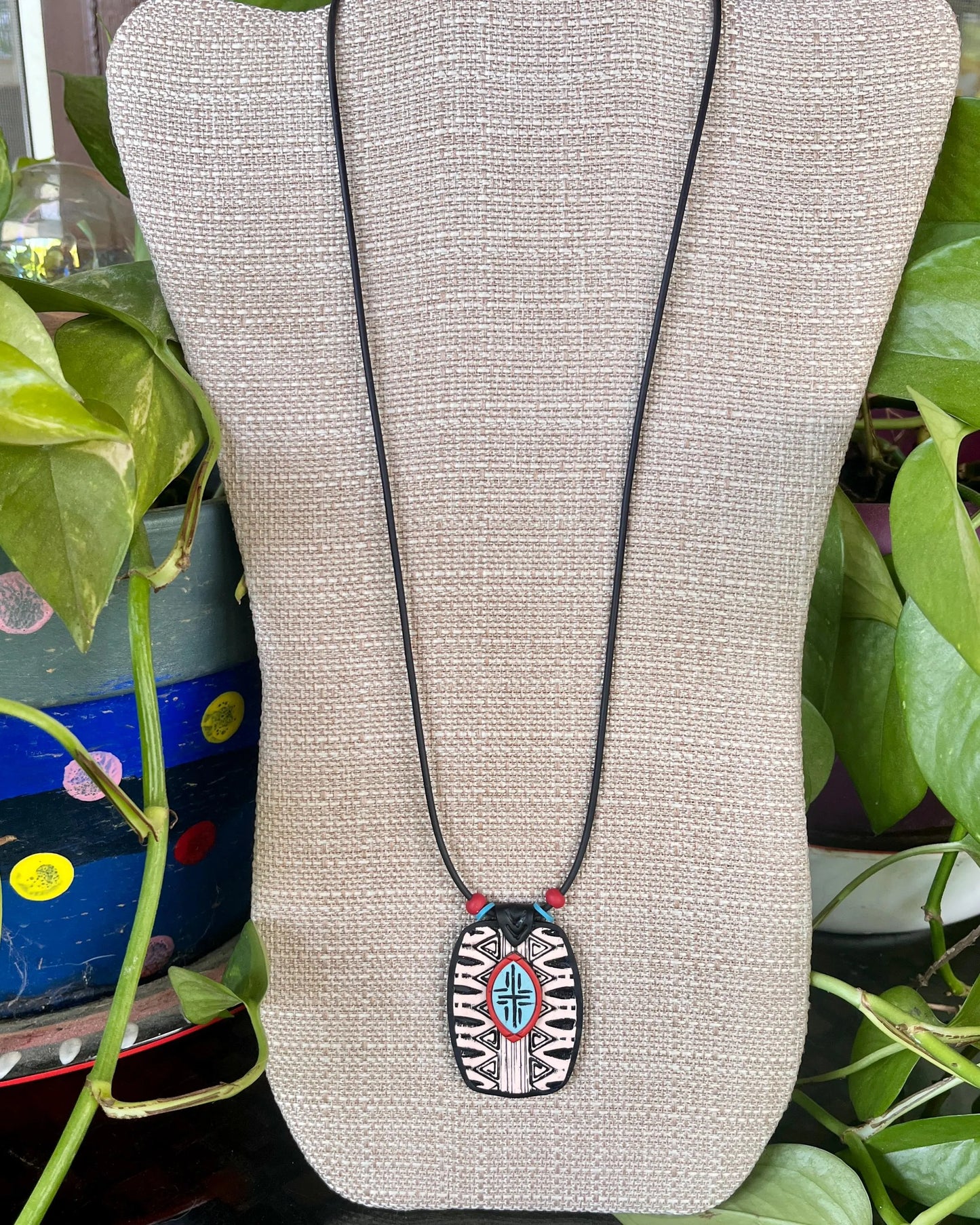 Beautiful, distinctive tribal textured, and layered polymer clay pendant. Black and white with turquoise and rust accents.